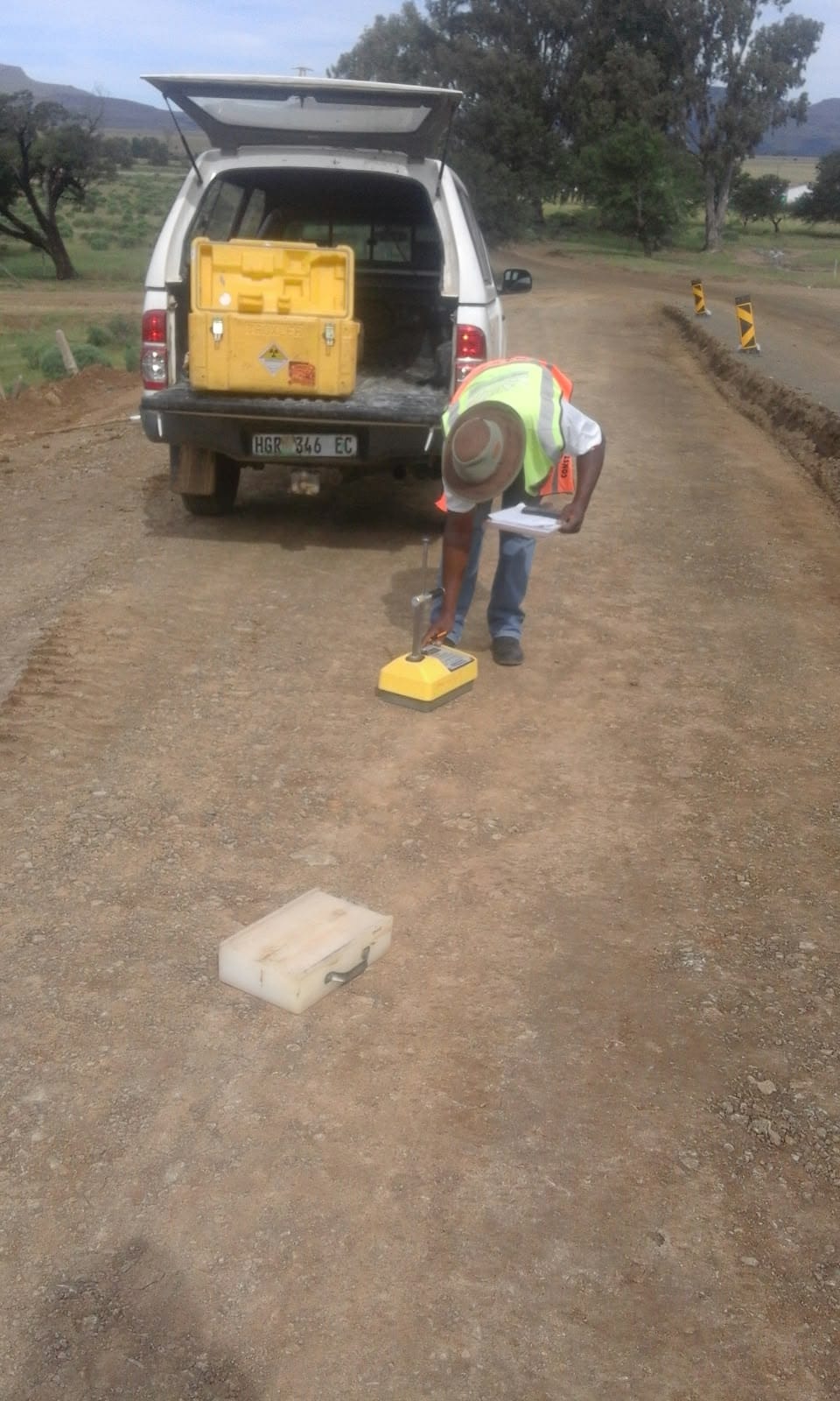 Umhlaba technician taking a nuclear density reading on a gravel road layer